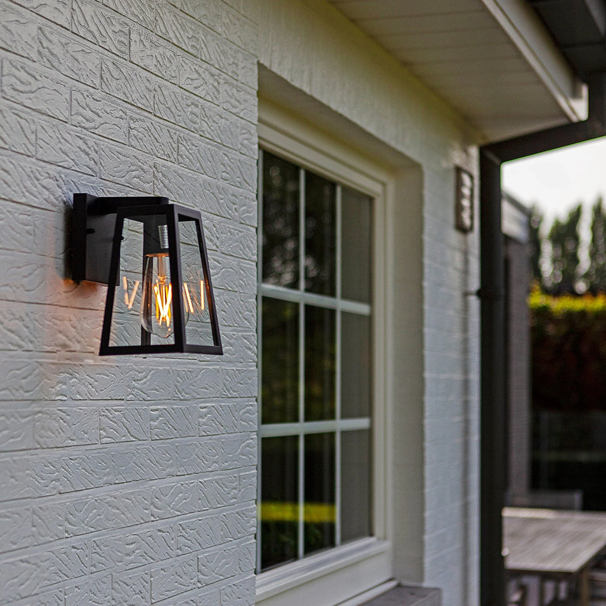 Outdoor installation of aluminium black wall light with LED filament globe.