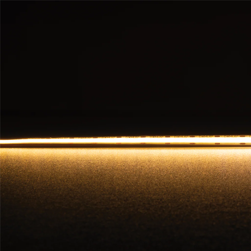 Thin gold strip Domus Plex COB 5 IP54 LED strip 24V 1 meter lighting on a black background