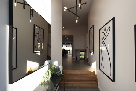 A hallway in a modern home illuminated by a pendant light and downlights