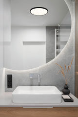 Modern bathroom with a white sink, mirror, and decorative elements.