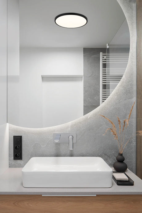 Modern bathroom with a white sink, mirror, and decorative elements.