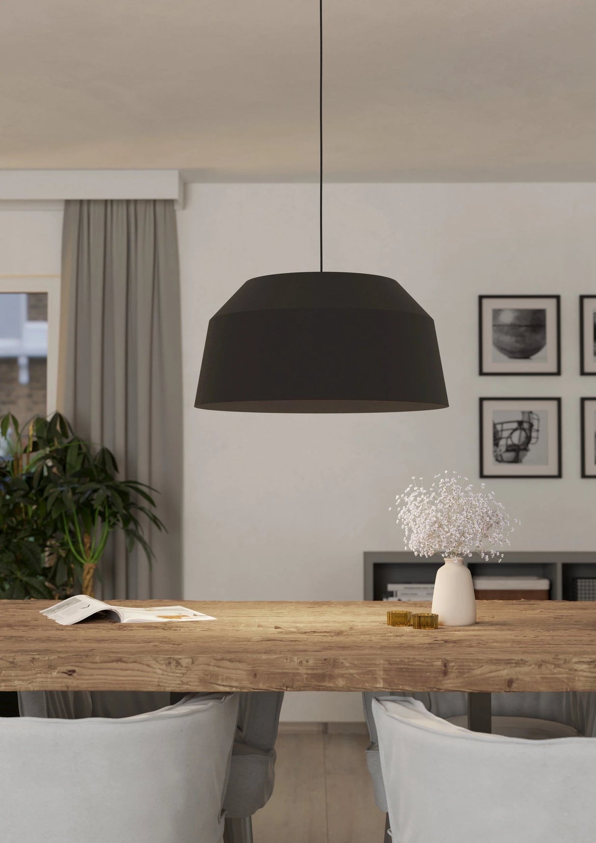 Modern dining room with a black pendant light, wooden table, and white chairs.
