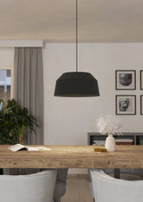 Modern dining room with a wooden table, black pendant light, and framed pictures on the wall.