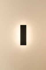 Modern wall-mounted light fixture on a beige wall