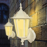 White outdoor wall lamp with yellow light on a stone wall background