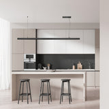 Modern kitchen with white cabinets, black backsplash, and bar stools.