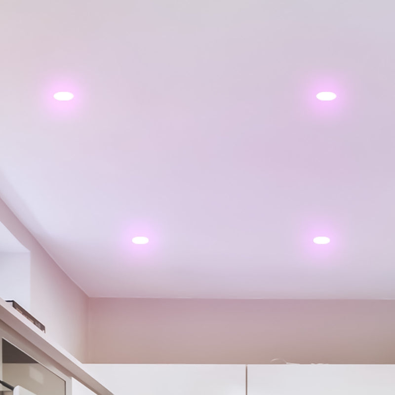 Ceiling with recessed lighting fixtures emitting a purple glow.