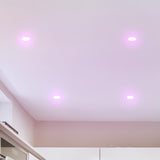 Ceiling with recessed lighting fixtures emitting a purple glow.