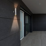 Modern outdoor wall light fixture on a dark tiled wall.