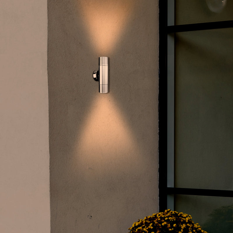 Modern wall-mounted outdoor light fixture on a concrete wall with a soft glow.