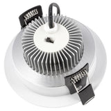 Close-up of a ceiling light fixture with metallic finish and black clips on a white background