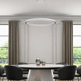 Modern dining room with a round table and chairs, featuring a ceiling light fixture.